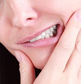 Closeup of grimacing patient holding jaw