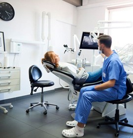 Dentist and patient together in treatment room