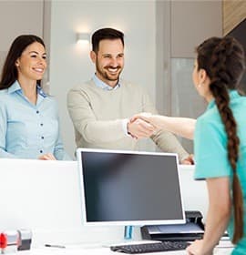 Two people checking in at front desk