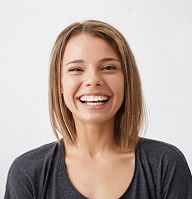 Close-up of a woman in a grey shirt smiling