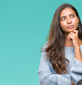Woman tapping her chin in a questioning pose