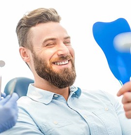 Young woman admires her new dental implants in Brampton