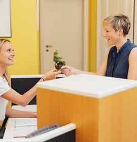 A woman using a credit card to pay for her dental care