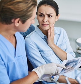 dentist pointing to model of dental implants in Brampton