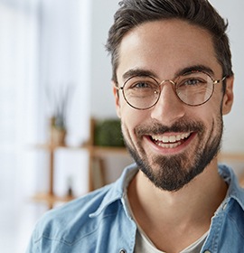 dentist pointing to model of dental implants in Brampton