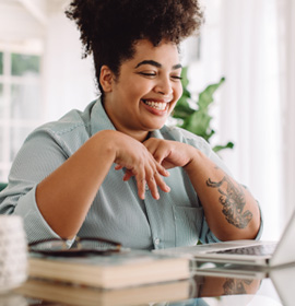Woman smiling while working on laptop at home