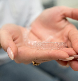Closeup of patient holding clear aligner