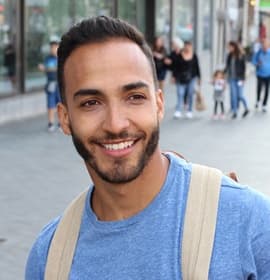 person smiling and walking down a city street