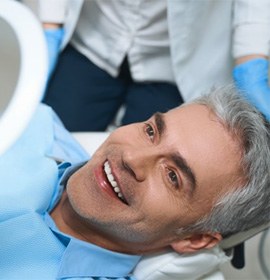 a patient smiling after receiving treatment from his implant dentist 