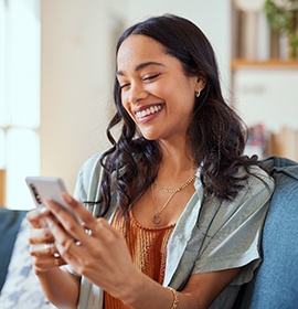 Woman holding her phone and sitting on the couch