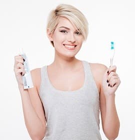 Woman holding toothpaste and toothbrush