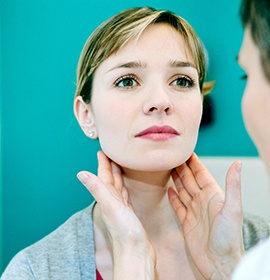 Dental team member examining patient’s lymph nodes during oral cancer screening