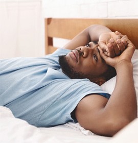 Man with sleep apnea in Brampton, ON lying awake in bed