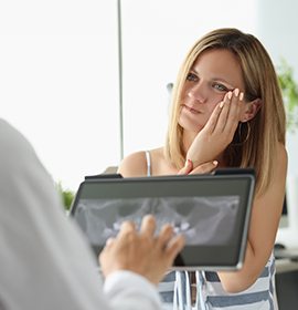 A young woman consulting her dentist about a toothache