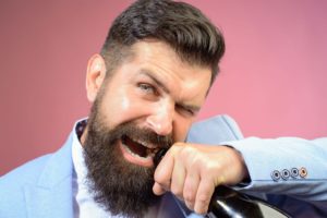 man opening bottle with teeth