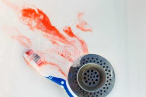 Bloody toothbrush in sink