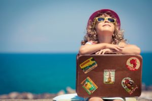 Child on beach with suitcase