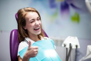 Woman in Dental Chair giving Thumbs Up