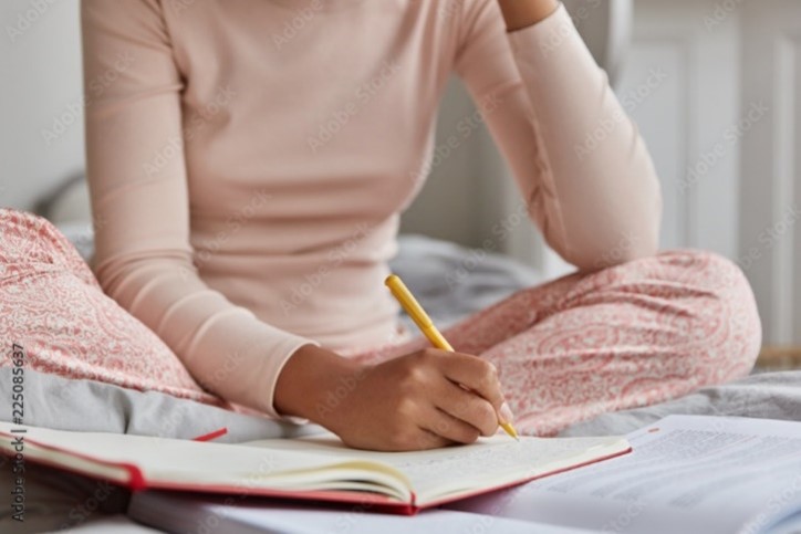 Woman writing in her sleep diary.