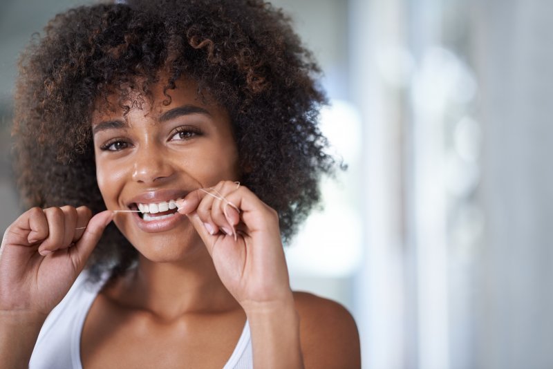 Young woman flossing with a smile