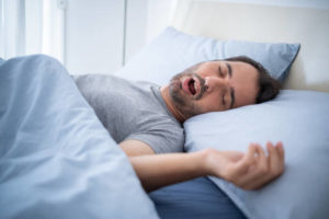 Snoring man laying in bed