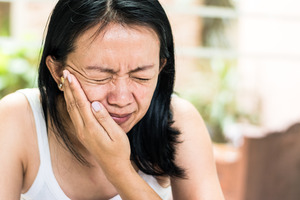Close-up of a woman with facial pain